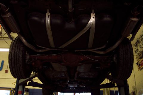 2001 Ford Crown Victoria - Undercarriage view of a vehicle, highlighting the fuel tank, dual exhaust system, and rear axle assembly.