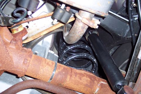 2001 Ford Crown Victoria - Close-up view of the rear suspension system, showing various metal components and a coil spring.