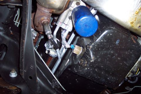 2001 Ford Crown Victoria - Close-up view of engine components including an oil filter and exhaust manifold.
