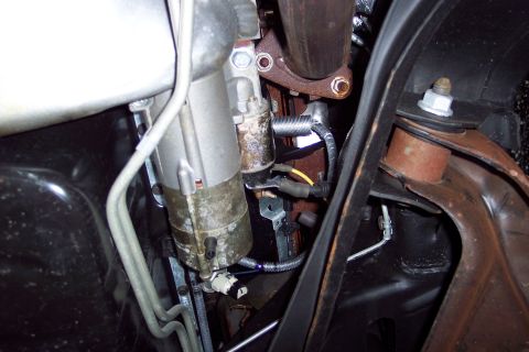 2001 Ford Crown Victoria - Underside view of a vehicle's starter motor and exhaust system components.