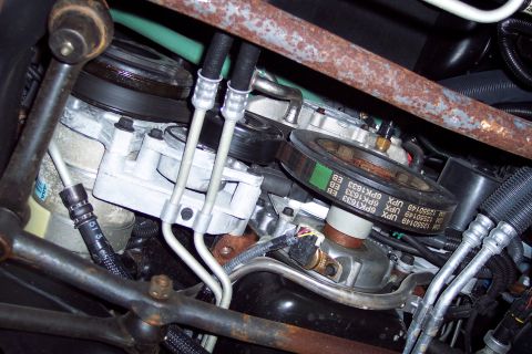 2001 Ford Crown Victoria - Close-up view of engine components, including a drive belt with visible part numbers.