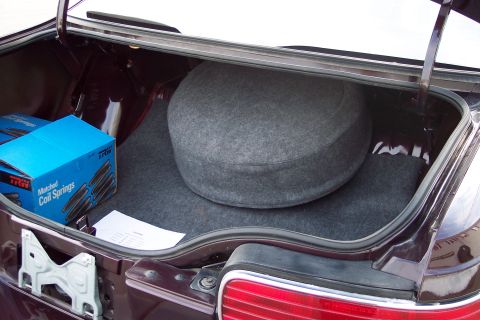 2001 Ford Crown Victoria - Trunk interior with spare tire and boxes of TRW coil springs.