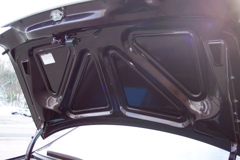 2001 Ford Crown Victoria - The underside of the hood on a 2001 Ford Crown Victoria shows structural bracing and a sticker with information.