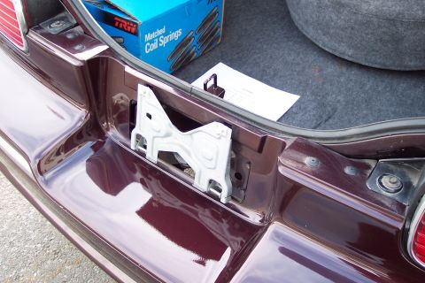 2001 Ford Crown Victoria - Trunk interior with a metal bracket and a box of TRW matched coil springs visible.
