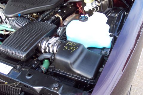2001 Ford Crown Victoria - Close-up of a car's engine bay, showing the air intake system and coolant reservoir.