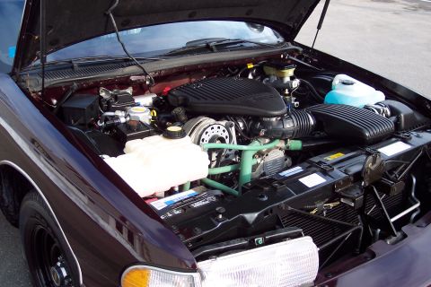 2001 Ford Crown Victoria - The engine bay of a 1996 Chevrolet Caprice is displayed with the hood raised, revealing the engine components.