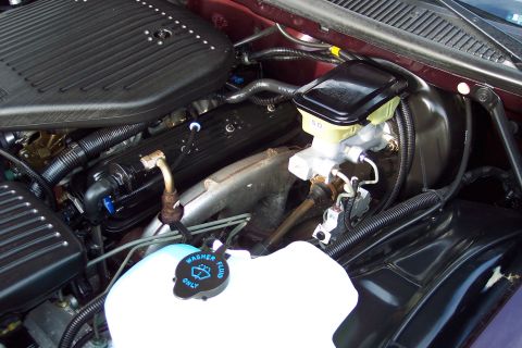 2001 Ford Crown Victoria - Close-up view of the engine bay, showing the washer fluid reservoir and brake fluid reservoir.