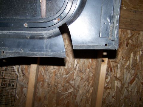 1988 Suzuki Samurai - A metal panel with a curved edge is stored indoors, supported by wooden beams.