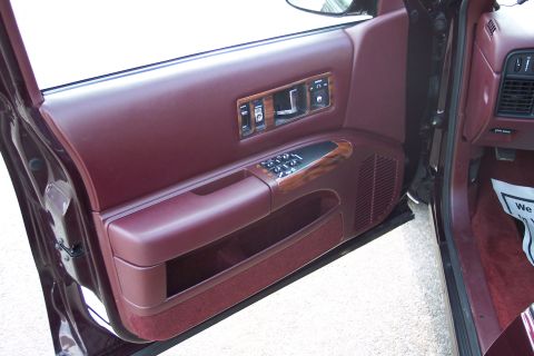 2001 Ford Crown Victoria - The interior door panel shows maroon upholstery and wood accents, with visible power controls.