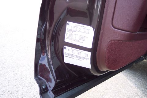 2001 Ford Crown Victoria - Close-up of a door jamb sticker providing tire loading information and vehicle manufacturing details.