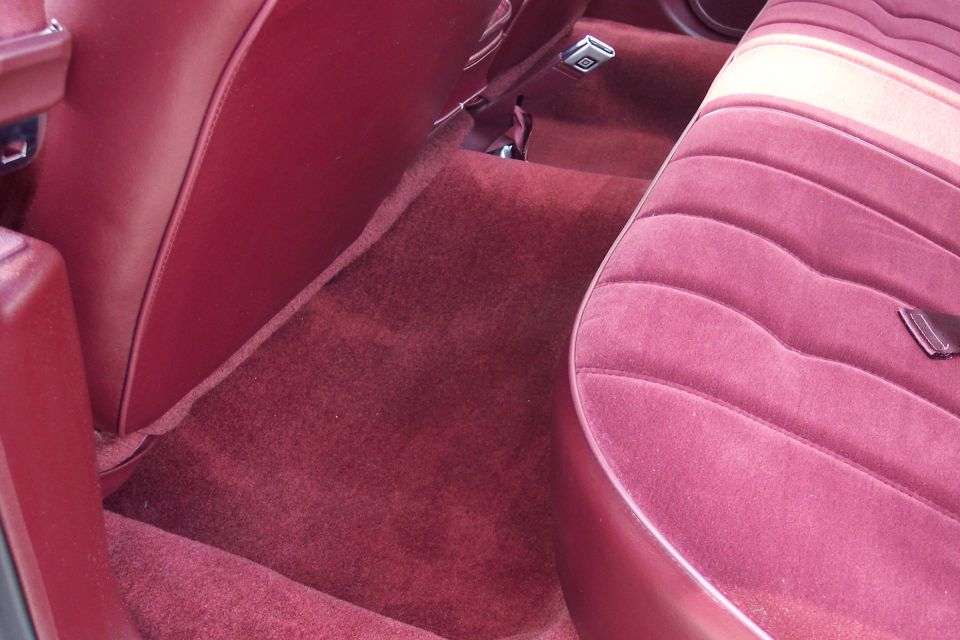 Maroon velour seat and carpet in a car interior