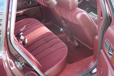 2001 Ford Crown Victoria - The interior of this 1996 Chevrolet Caprice sedan features maroon velour upholstery and a visible 'We Take' sign on the dashboard.