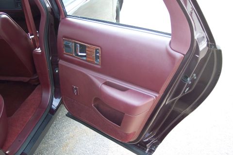 2001 Ford Crown Victoria - Interior view of a maroon door panel with wood trim and matching seat upholstery.