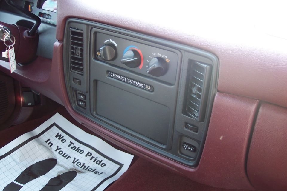 Caprice Classic dashboard with climate controls and "We Take Pride In Your Vehicle!" floor mat