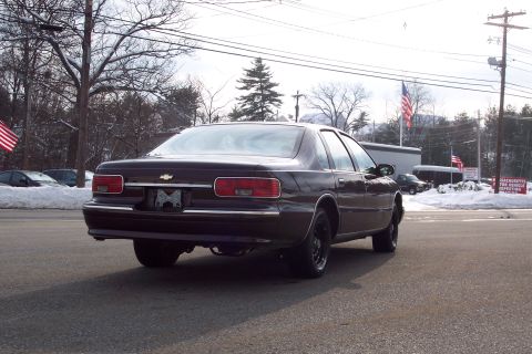 2001 Ford Crown Victoria - A dark sedan is parked on a road with snow visible in the background.