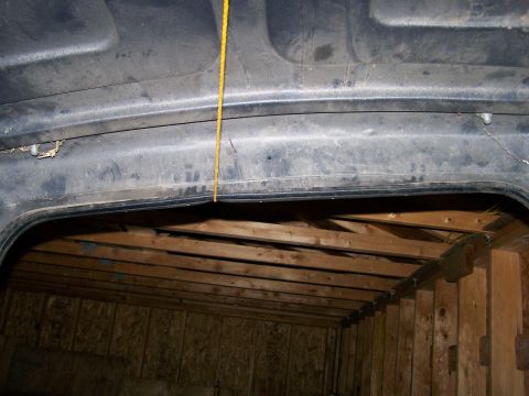1988 Suzuki Samurai - Looking up at the inside of a vehicle's hardtop, with a rope dangling and wooden structure below.