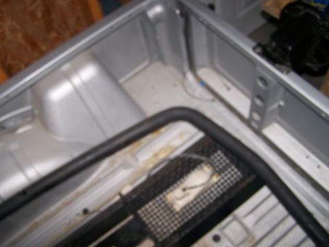1988 Suzuki Samurai - The interior of a vehicle bed shows a silver finish, a black roll bar, and a metal grate with wiring.