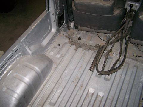 1988 Suzuki Samurai - The interior of a silver vehicle's bed and seats is visible, with a gear shift and wiring present.
