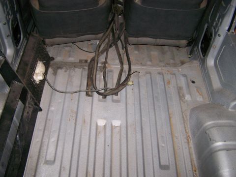 1988 Suzuki Samurai - Interior view of the cargo area in a 1988 Suzuki Samurai, showing seats and exposed wiring.