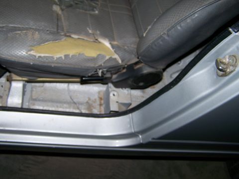 1988 Suzuki Samurai - Interior view of a vehicle showing a damaged driver's seat and floor area.