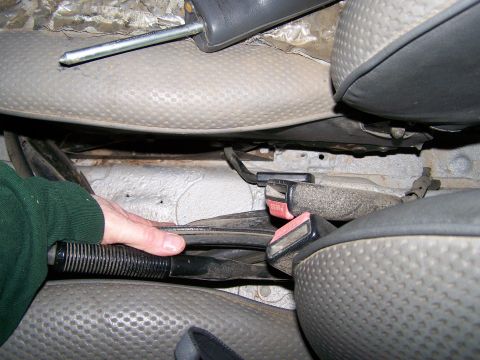 1988 Suzuki Samurai - Interior view of vehicle seats and parking brake mechanism, with a hand engaged.