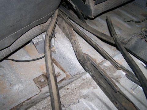 1988 Suzuki Samurai - Close-up of the vehicle's interior floor, showing various rubber seals and wiring harnesses.