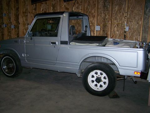 1988 Suzuki Samurai - Silver 1988 Suzuki Samurai pickup truck with a soft tonneau cover over the bed.