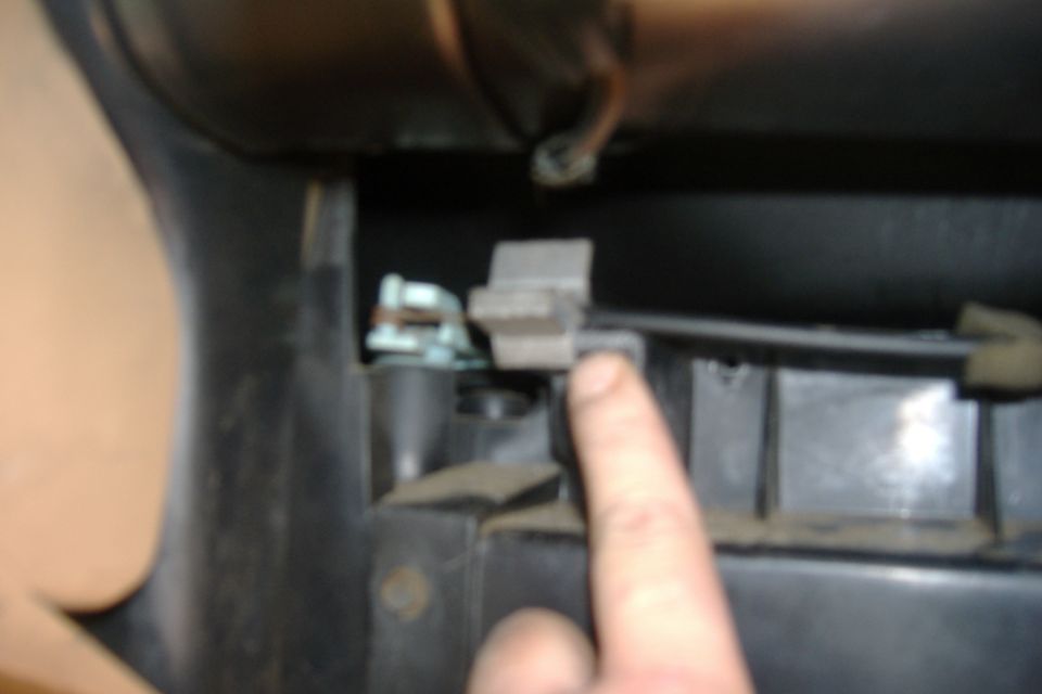 A blurry close up of the air flow direction line.  Take the clip off (gray thing next to my finger) and then slide the wire up and off.