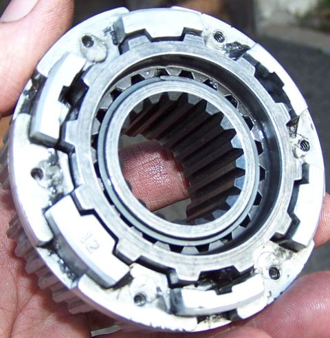 1990 Ford Bronco - A metal gear part, possibly from a transmission or transfer case, is held in a hand. The number '12' is visible on the part.