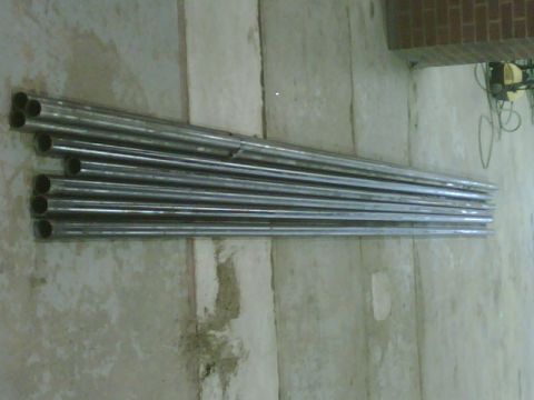 1996 Ford Bronco - Several metal tubes are piled together against a textured concrete wall.