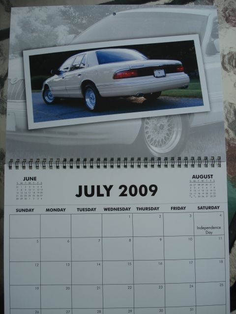 2000 Ford Crown Victoria - A cream-colored sedan is pictured from the rear quarter angle, highlighting its taillights and distinctive alloy wheels.