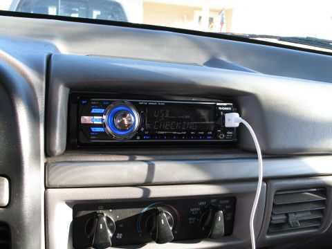 1995 Ford Bronco - Close-up of a car's dashboard showing an aftermarket Sony stereo connected to a USB device.