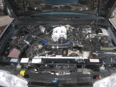 1996 Ford Thunderbird - The engine bay features a prominent supercharger and custom air intake system.