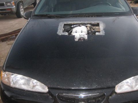 1996 Ford Thunderbird - A car's hood has been modified to expose the supercharger engine component.