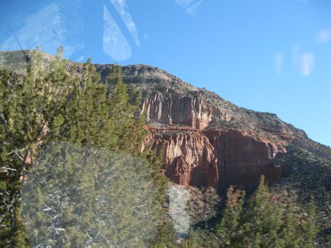 1993 Ford Bronco - A scenic view of a mountain range under a clear blue sky, with trees partially obscuring the landscape.
