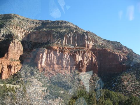 1993 Ford Bronco - A scenic view of layered red rock formations and arid vegetation under a bright blue sky.