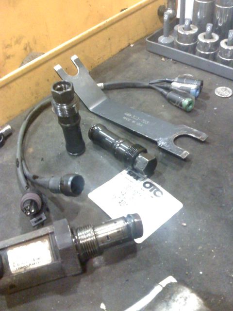 1992 Ford Bronco - Various automotive tools and components are laid out on a workbench, suggesting repair or maintenance work.