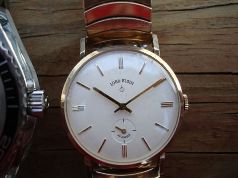 1994 Ford Bronco - Close-up of a vintage Lord Elgin wristwatch, a white dial and gold-toned case.