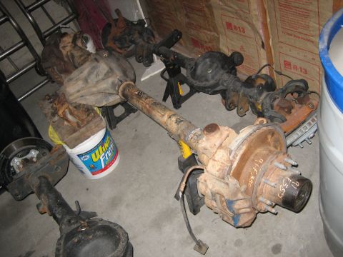 1990 Ford Bronco - Several rear axles are visible, with one clearly marked "91 F350", suggesting they are Ford truck parts.