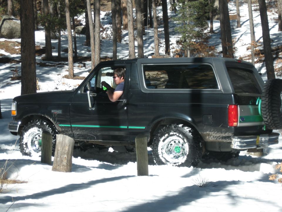Black 1993 Ford Bronco in snow, 3/4 front view with spare tire on back
