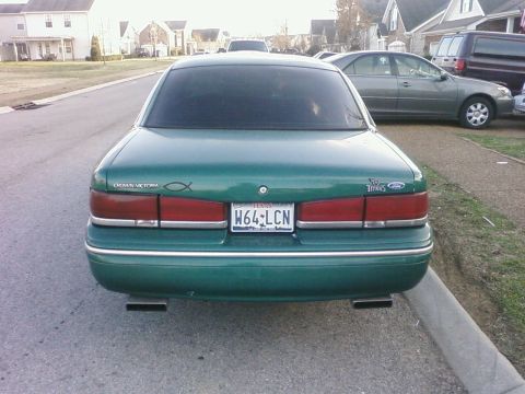 1997 Ford Crown Victoria - Rear view of a green 1997 Ford Crown Victoria parked on a residential street.