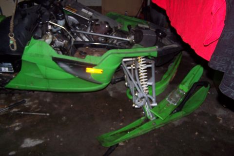 2004 Arctic Cat F-7 Firecat - A green snowmobile is shown with its front end lifted and engine exposed, parked indoors.