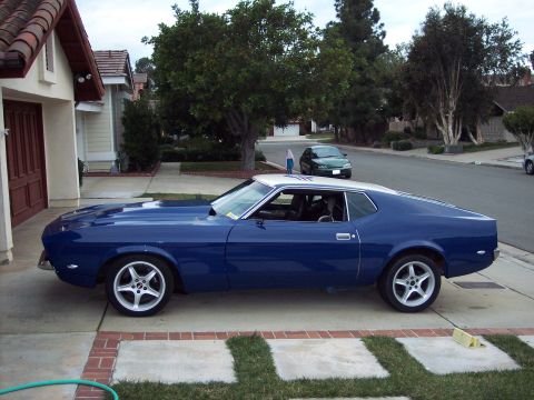 1971 Ford Mustang - Side view of a blue 1971 Ford Mustang coupe with a silver roof parked in a driveway.