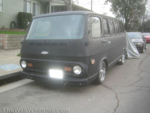 1968 Ford Mustang - A black panel van is parked on a street with other vehicles behind it.