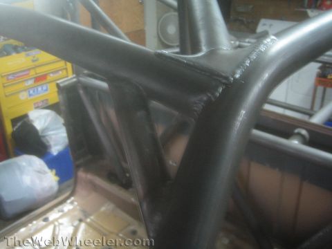 1990 Ford Bronco - Close-up of a fabricated tubular roll cage node showing several gusseted and welded tube joints meeting at one intersection.