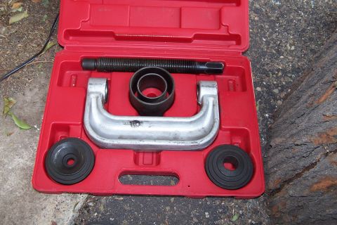1990 Ford Bronco - A ball joint press tool kit is shown in its red plastic case, ready for use on vehicle suspension components.