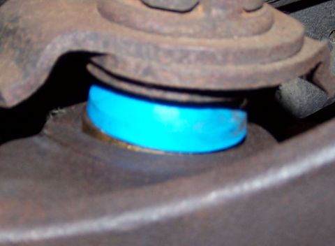 1990 Ford Bronco - A close-up view of a vehicle's suspension system, highlighting a ball joint with a blue polyurethane bushing.