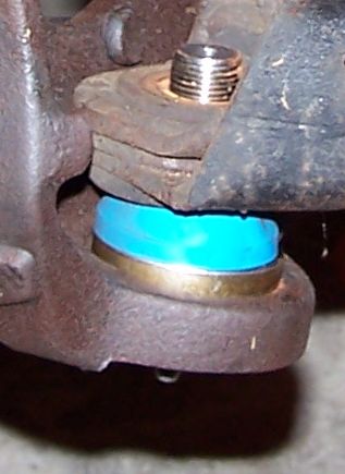 1990 Ford Bronco - A close-up view of a vehicle's ball joint, highlighting the bright blue boot and metal components.
