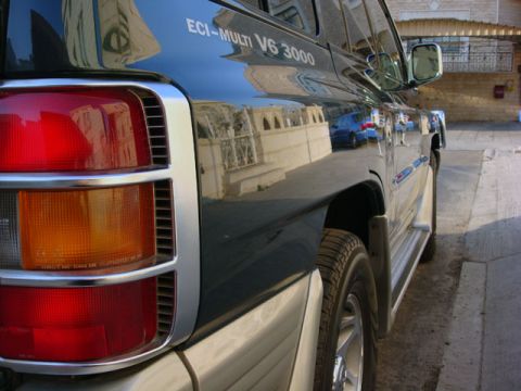 2000 Mitsubishi Montero - The rear of a dark blue 2000 Mitsubishi Montero is shown from a three-quarter front angle.
