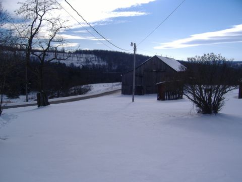 1988 Ford Bronco - A winter scene depicts a rustic barn and surrounding snow-covered landscape under a bright, cloudy sky.